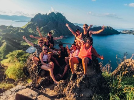 A group at the top of the viewpoint on Padar Island in Indonesia overlooking incredible views 