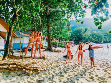 Five girls at bottle beach in Koh Phangan with two of them on the swing
