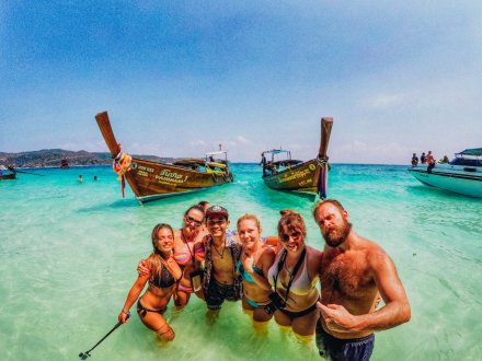 A group selfie in the crystal clear water by the long tail boats in West Thailand 